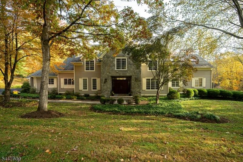 Fabulous custom built estate set on over 6 breathtaking, private acres boasting a pond a stream, tucked away on a quiet, tree lined street.
