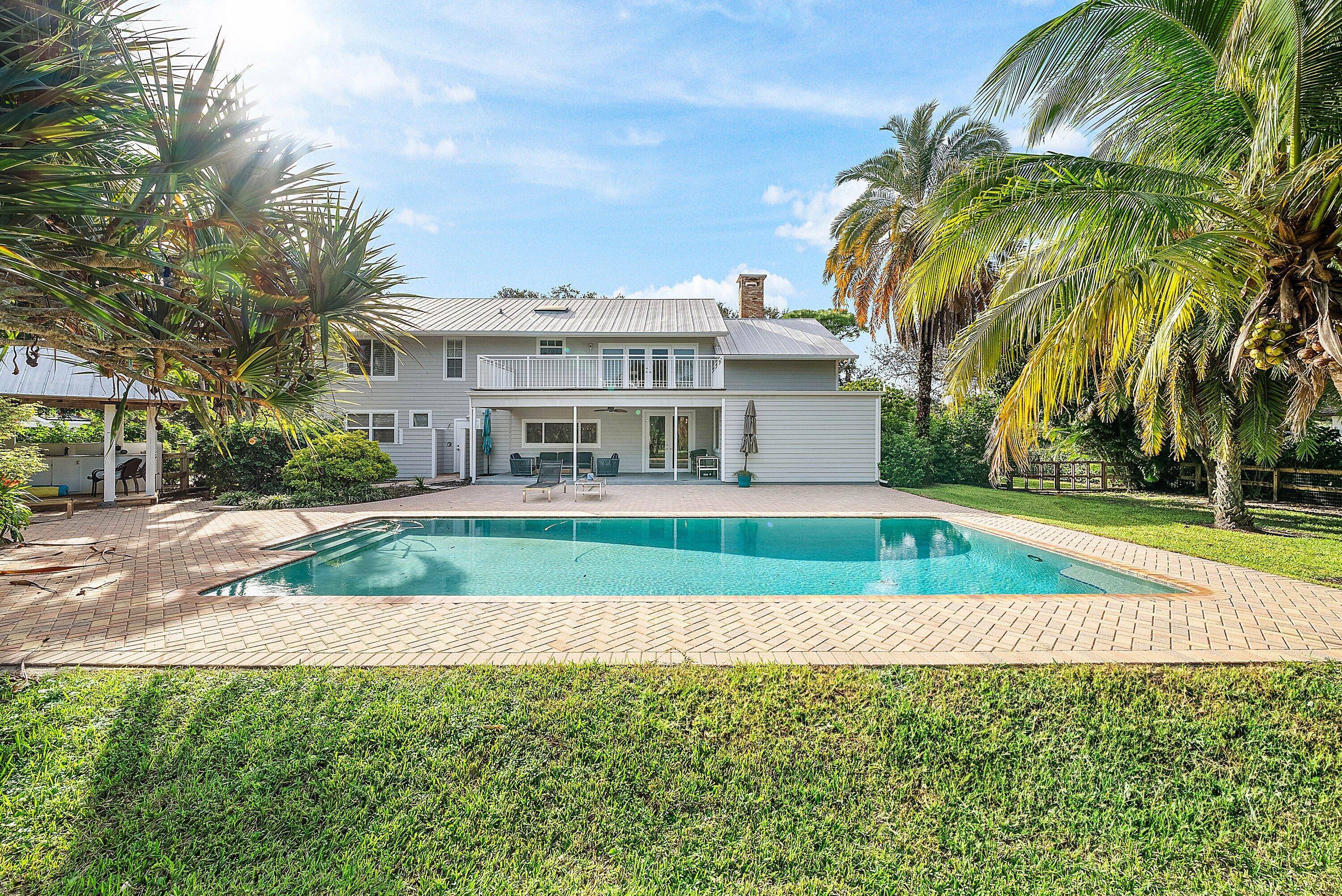 Set on over an acre in the prestigious community of Steeplechase, this beautifully landscaped property offers a lush, private retreat surrounded by graceful palm trees and vibrant gardens.