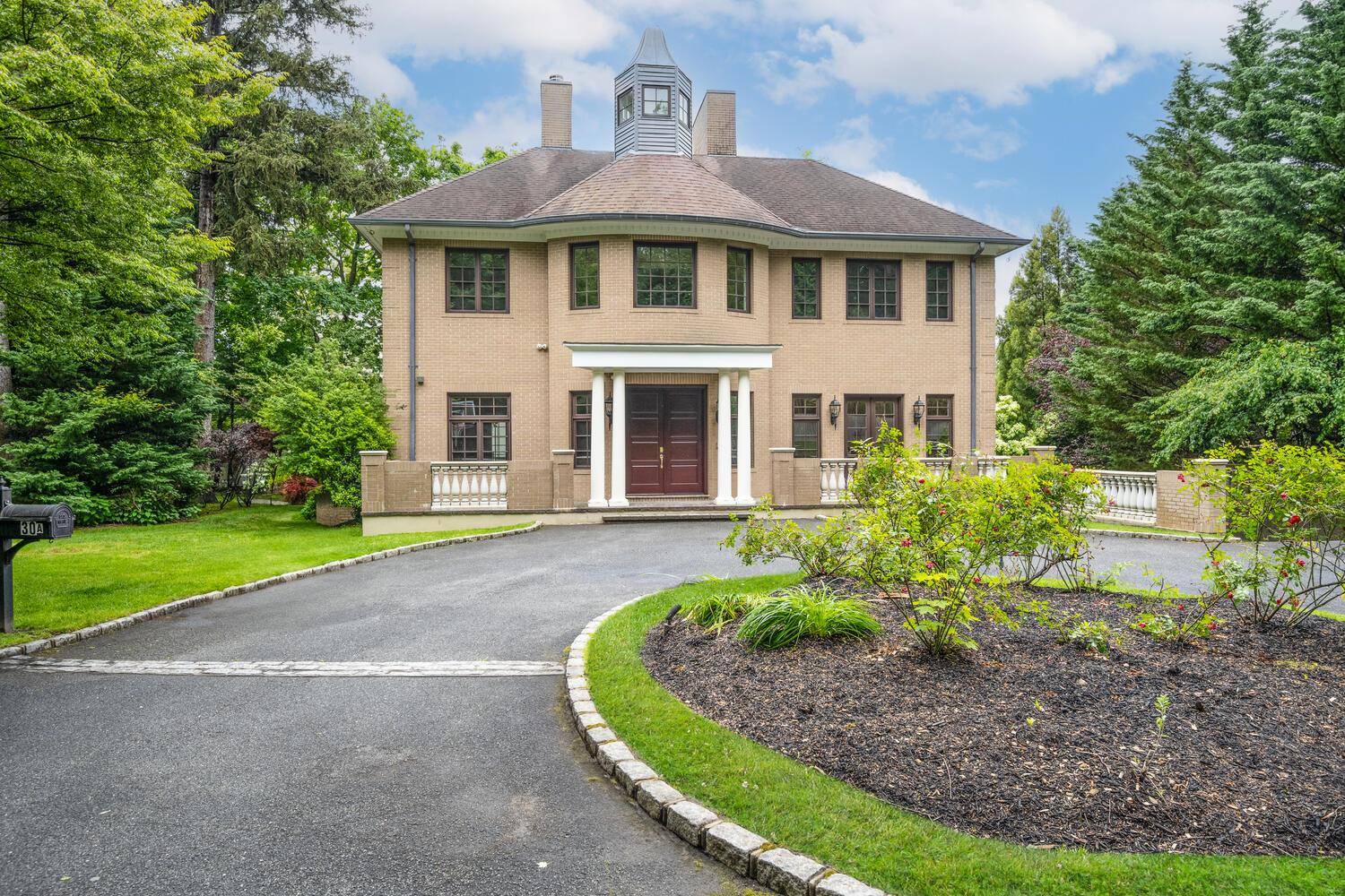 Behind a discreet gated entrance serving just two residences, this distinguished custom built brick Colonial offers a rare blend of privacy in the Village of North Hills.