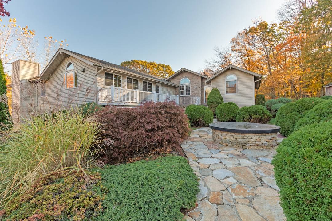 A stunning expanded ranch with an outdoor firepit and inground pool.
