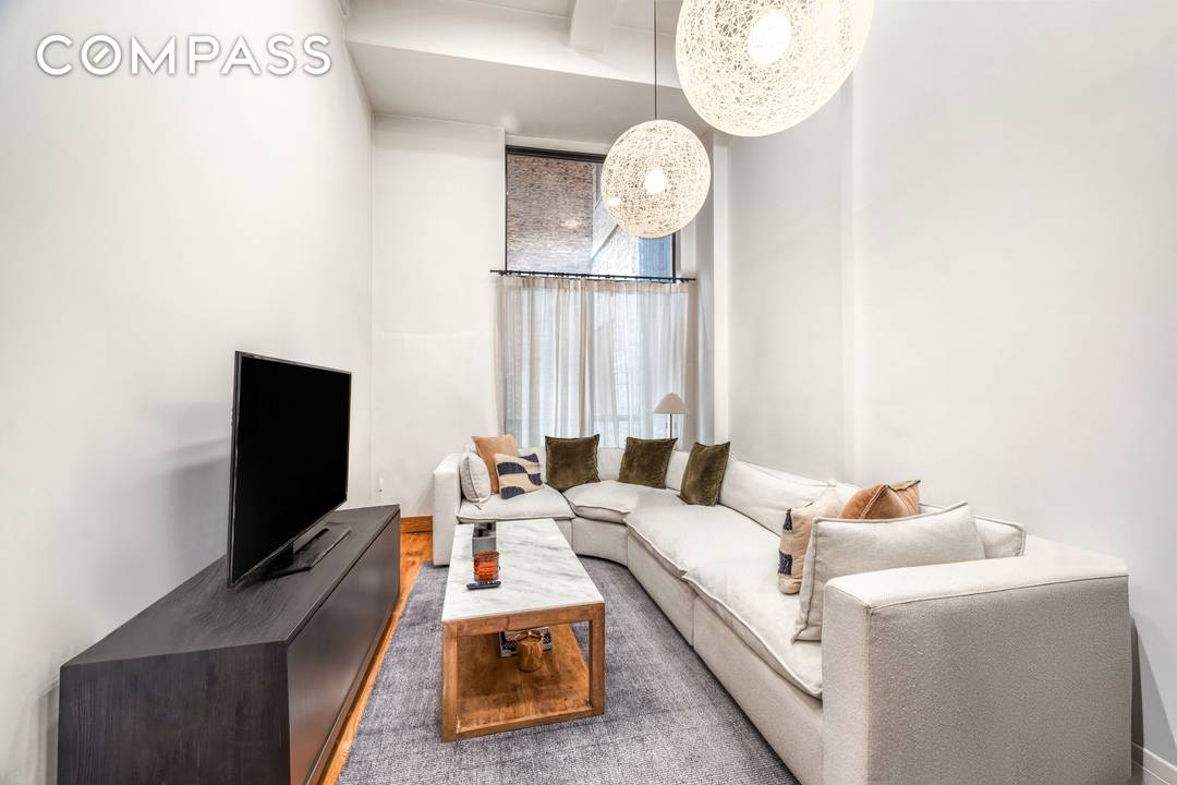 Welcome to apartment 3R, a 1 bed with dramatic interiors featuring soaring 14 foot ceilings, a wall of oversized windows, and a custom metal staircase leading to a lofted bedroom ...