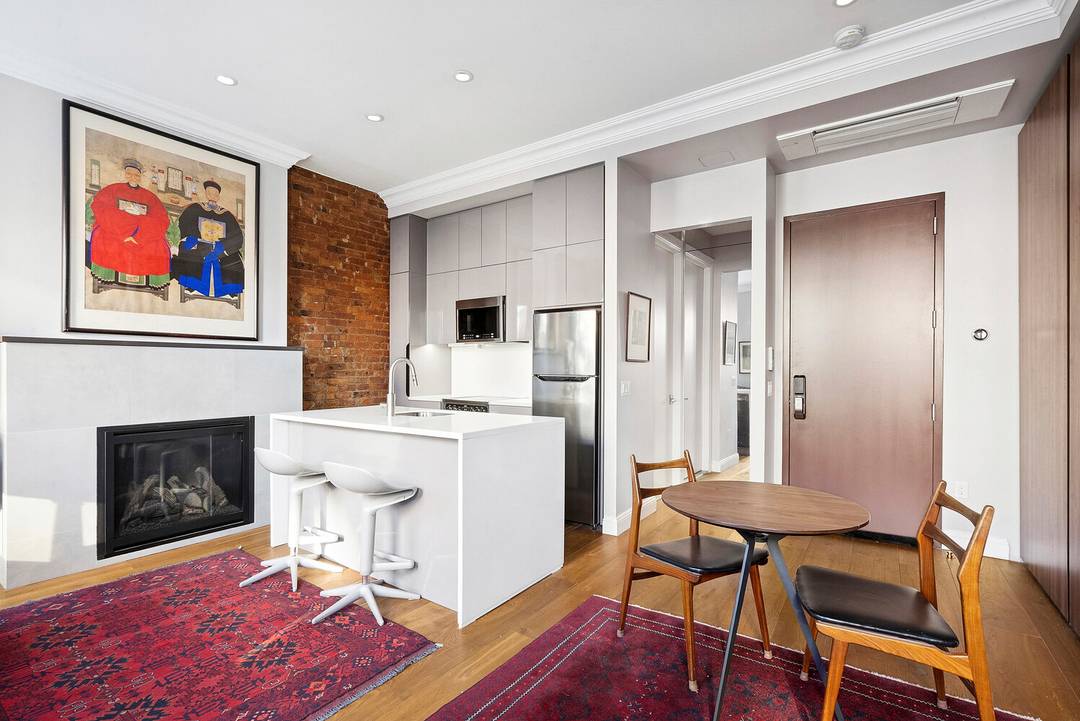 Furnished Beautifully renovated studio with high ceilings, a decorative fireplace, and open northwestern views through three oversized windows.