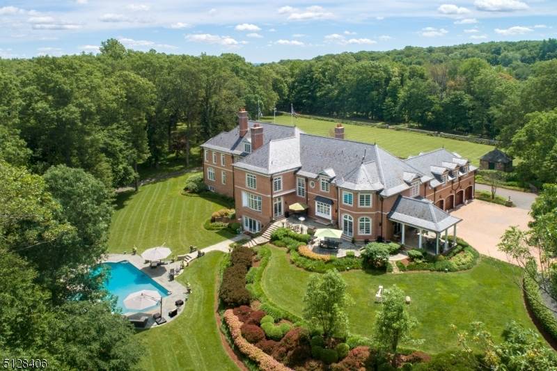 Perched atop prestigious Bernardsville Mountain, this custom built manor home is a masterwork of timeless design, exquisite craftsmanship, and serene natural beauty.