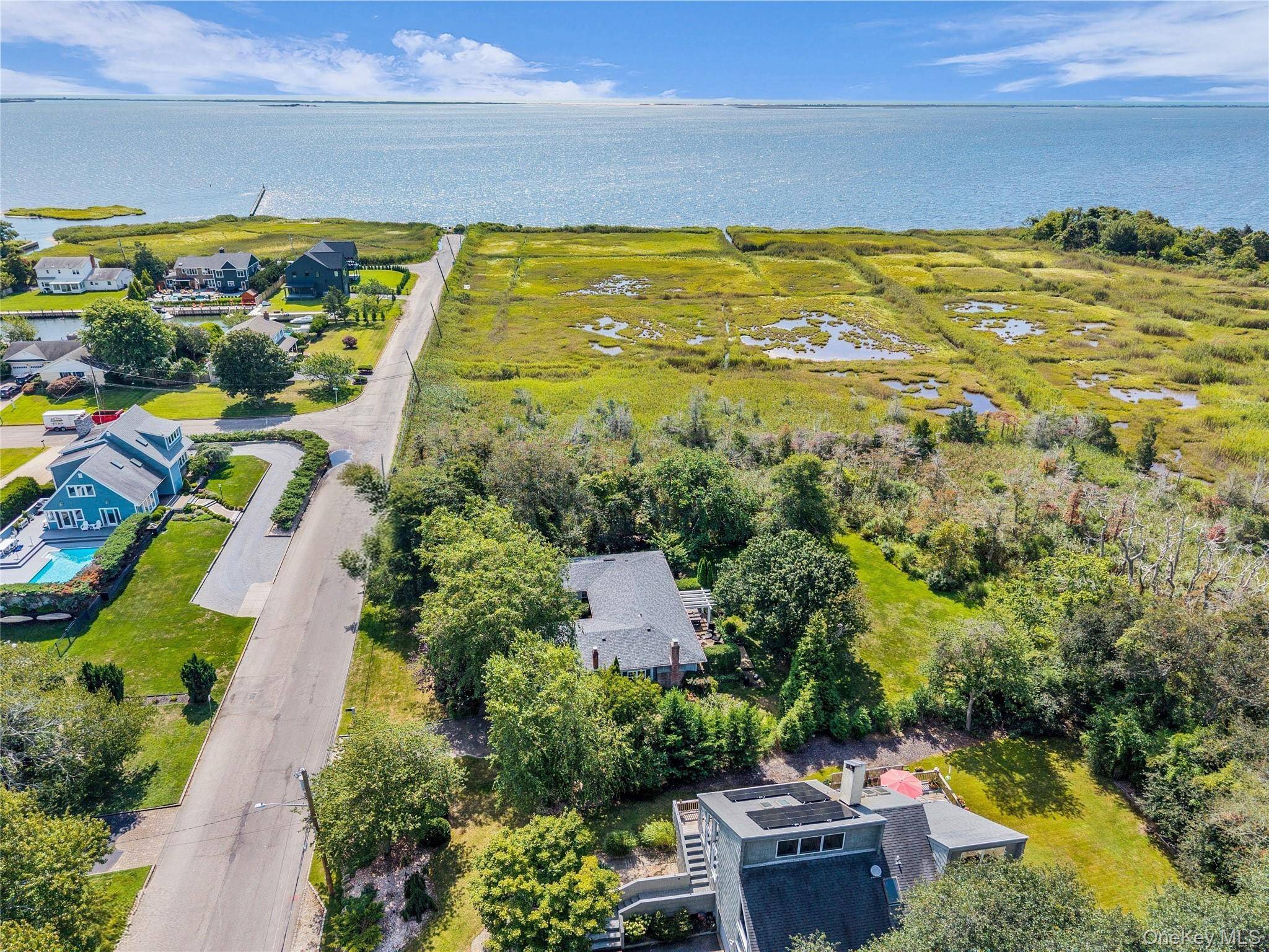Nestled within a tranquil enclave of Bellport, this thoughtfully designed single level ranch style home offers a blend of privacy, space, and potential on 1.