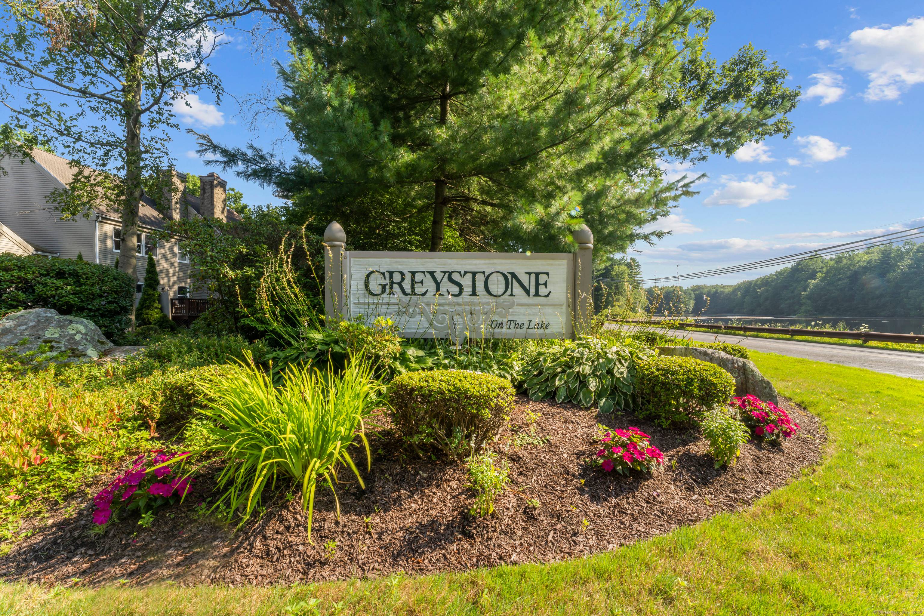 Nestled in the picturesque village of Huntington, this stunning Victorian style townhome offers timeless curb appeal and serene living in the sought after Greystone on the Lake community.