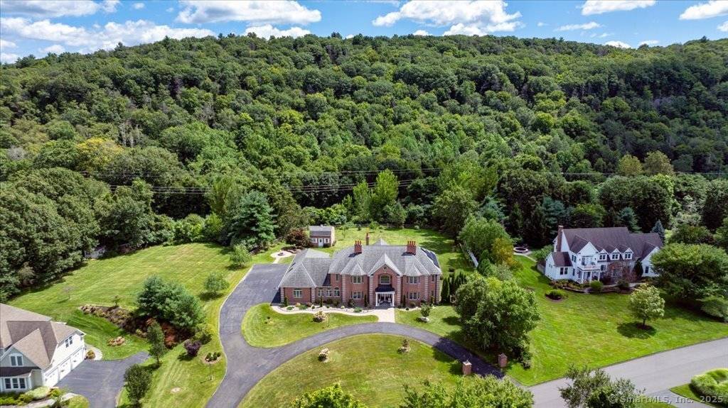 This stunning brick Colonial sits atop Hunting Ridge Drive on a sprawling two acre level lot, offering panoramic views of the Farmington Valley and breathtaking sunsets !