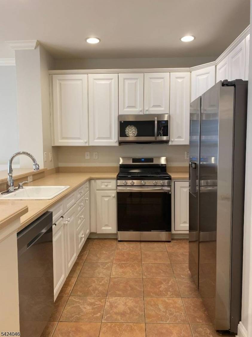 Bright Albright model open floor plan living room, recessed lights, gas fireplace, wood flooring and sliders to outside patio level grass area, Corian.