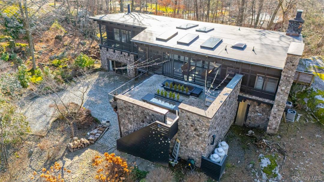 MIDCENTURY MODERN A SEAMLESS CONNECTION WITH NATURE Nestled atop a striking boulder with panoramic views of Sterling Forest State Park, this spectacular home is a true masterpiece.