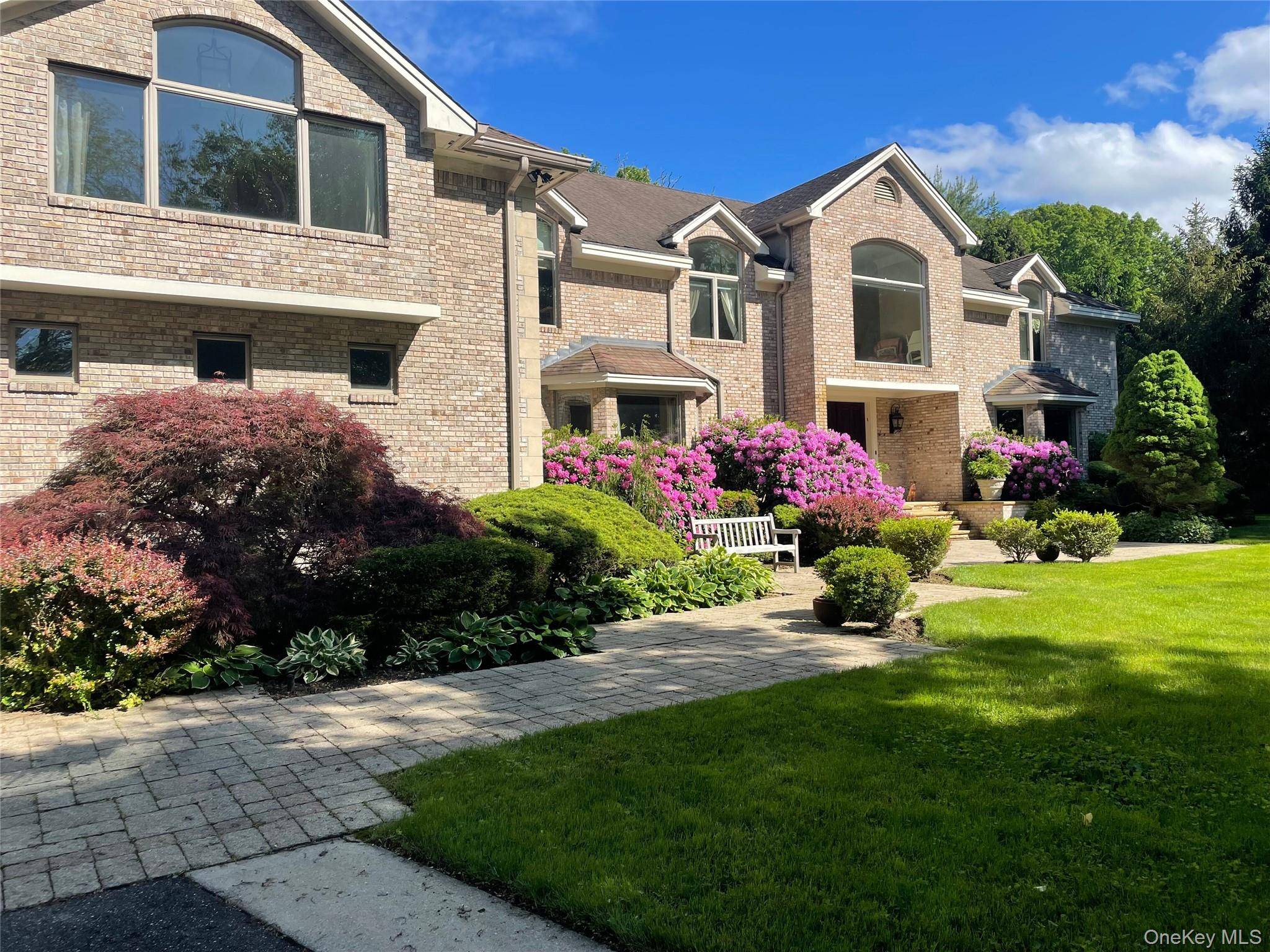 527 Split Rock Road is a beautiful custom built brick and stucco Colonial home set on 2 professionally landscaped, tranquil acres in the Syosset SD.