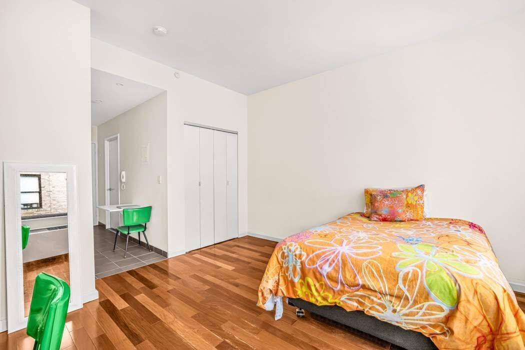 Apartment PH08, Penthouse studio features the modern galley kitchen has stainless steel appliances, granite countertops, outfitted with walnut and glass cabinetry, and includes a storage pantry.