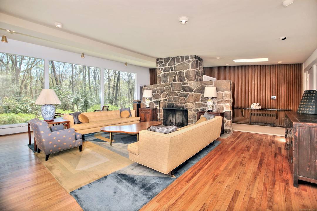 Discover the charm of this mid century modern home, bathed in natural sunlight thanks to large windows that frame stunning views of the lush landscaping and nature outside.