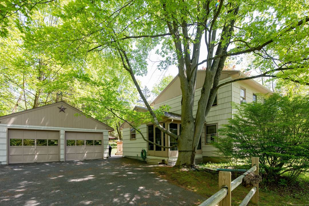 Beautifully maintained home sits above the road with nicely landscaped, private yard, paved driveway and two car garage with an additional car port.