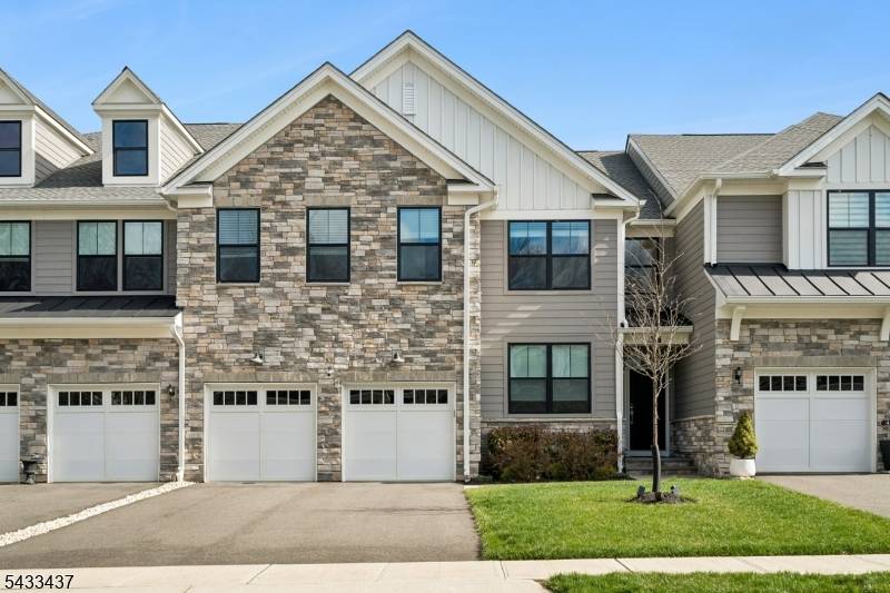 The Amberley model showcases a chef's dream kitchen with upgraded stone countertops featuring rounded edges, designer lighting, stainless steel appliances, and a gas cooktop.