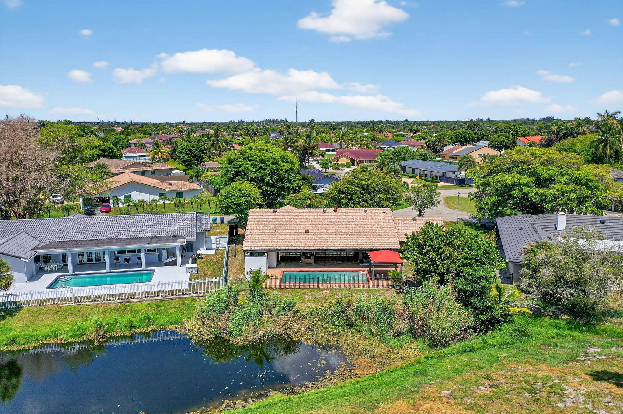 Stunning 4BR 2BA waterfront pool home in prestigious Country Club of Miami on the desirable NO HOA side, enjoy spectacular golf water views without fees or restrictions.