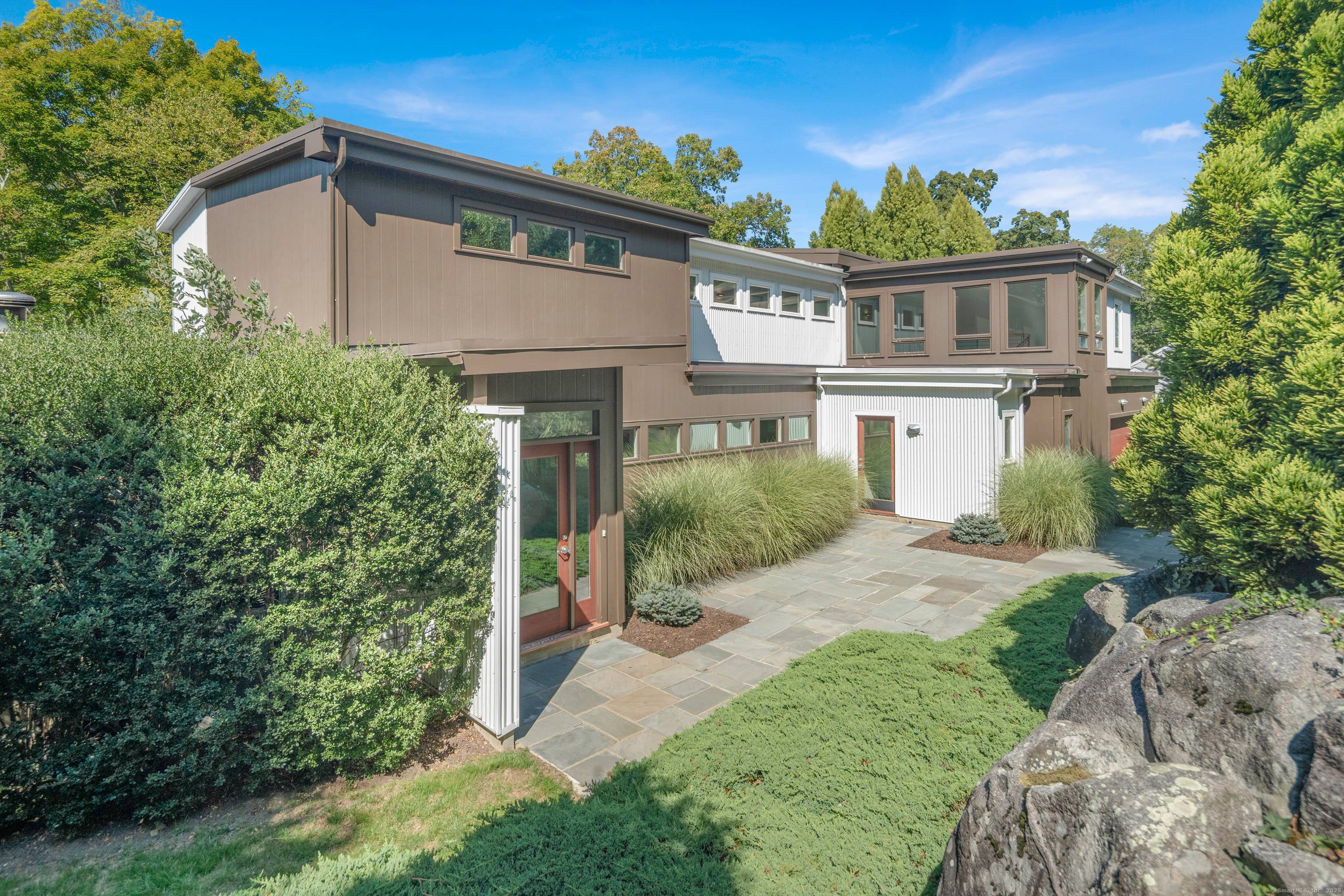 Perched high above the Goodwives River, this stunning Mid Century Modern home offers sophisticated living in an extraordinary natural setting.