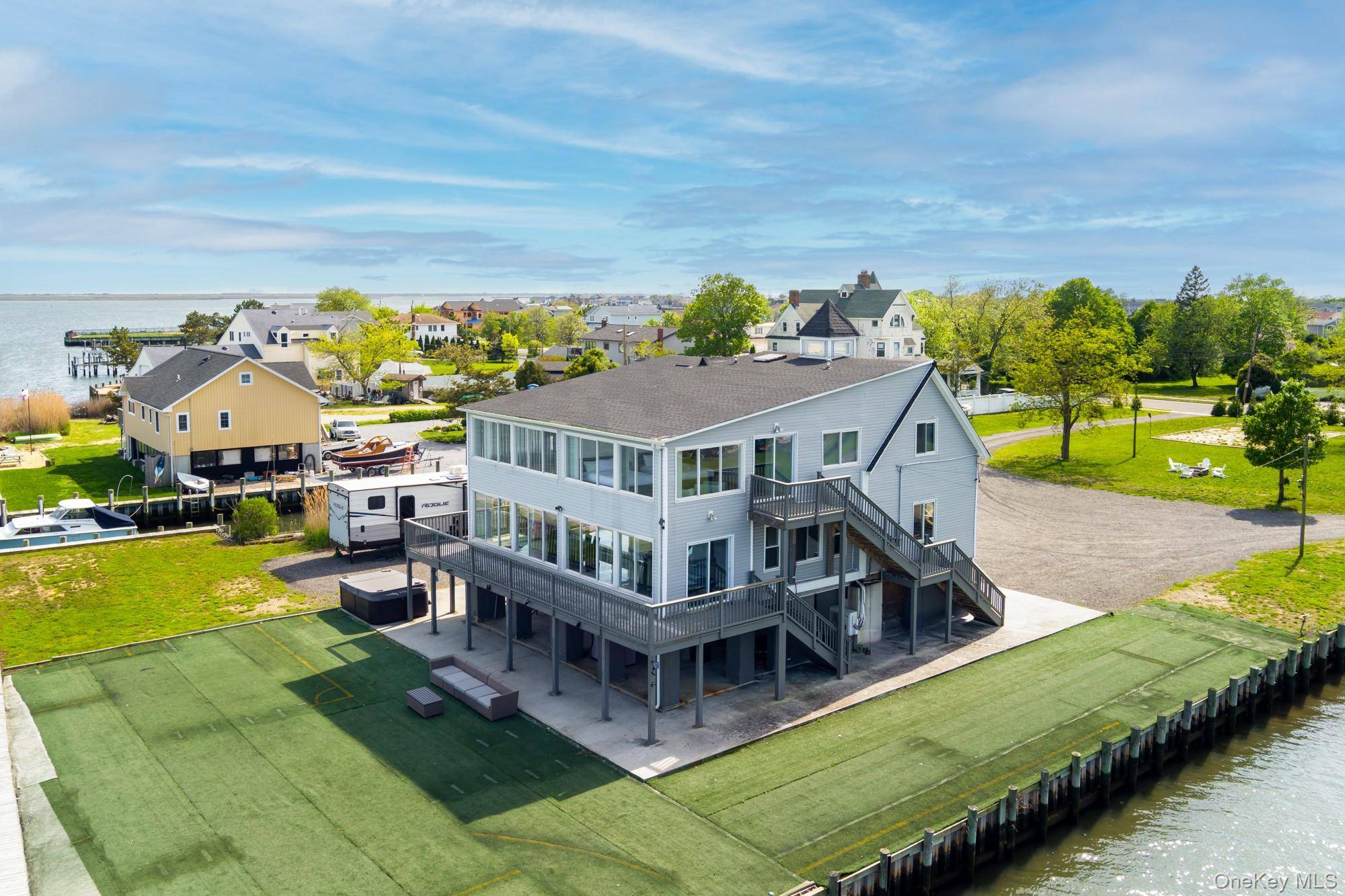 Welcome to 200 Clocks, a rare waterfront opportunity offering 200 feet of bulkhead and boat slips on three sides, just minutes from Breezy Point Park and the open bay.
