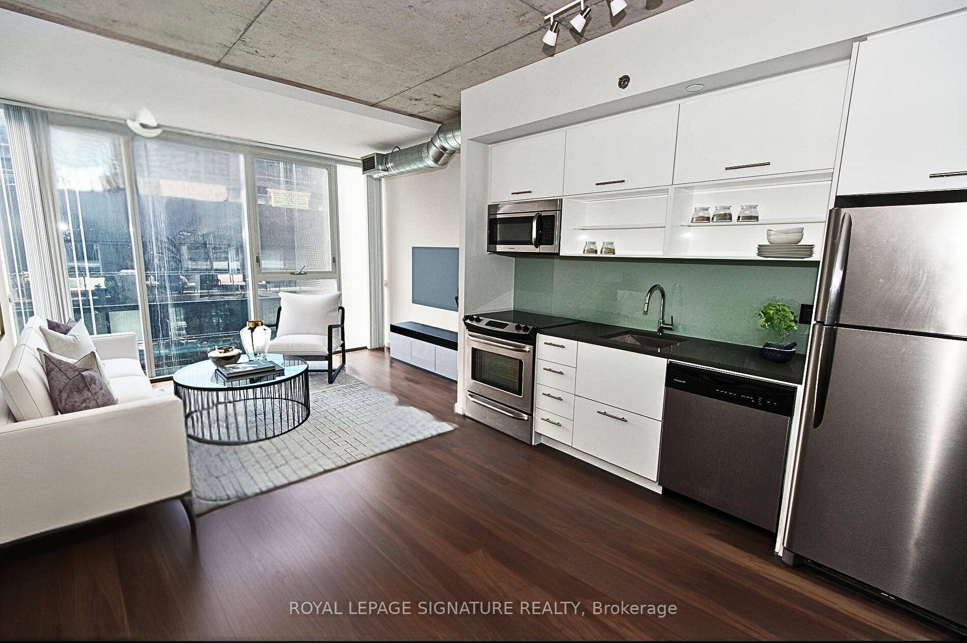 This bright sun soaked open concept unit features 9ft exposed concrete ceilings, floor to ceiling windows with modern kitchen.