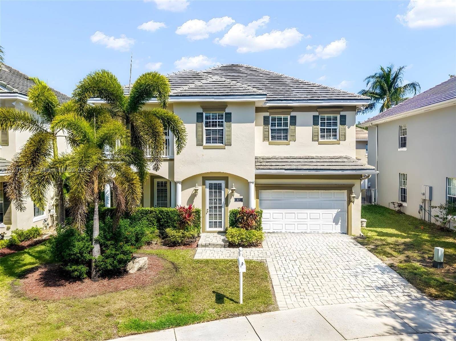 Beautiful Georgian style home located in a gated community in Fort Lauderdale, surrounded by two serene lakes and scenic footbridges.