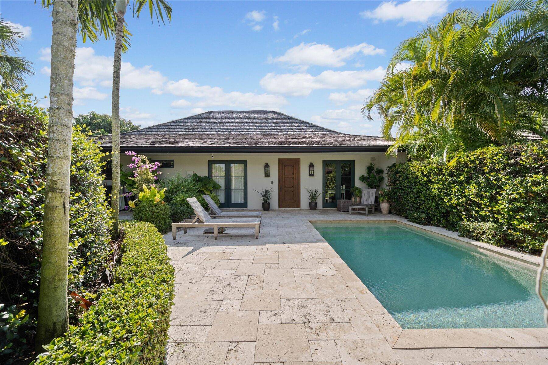 Enter through the secret garden of this sophisticated courtyard bungalow with private heated pool and stunning backyard water views.