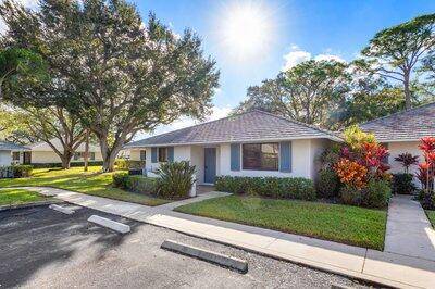 Welcome to 605 Club Drive a light filled 2 bedroom, 2 bath end unit villa in the heart of PGA National.