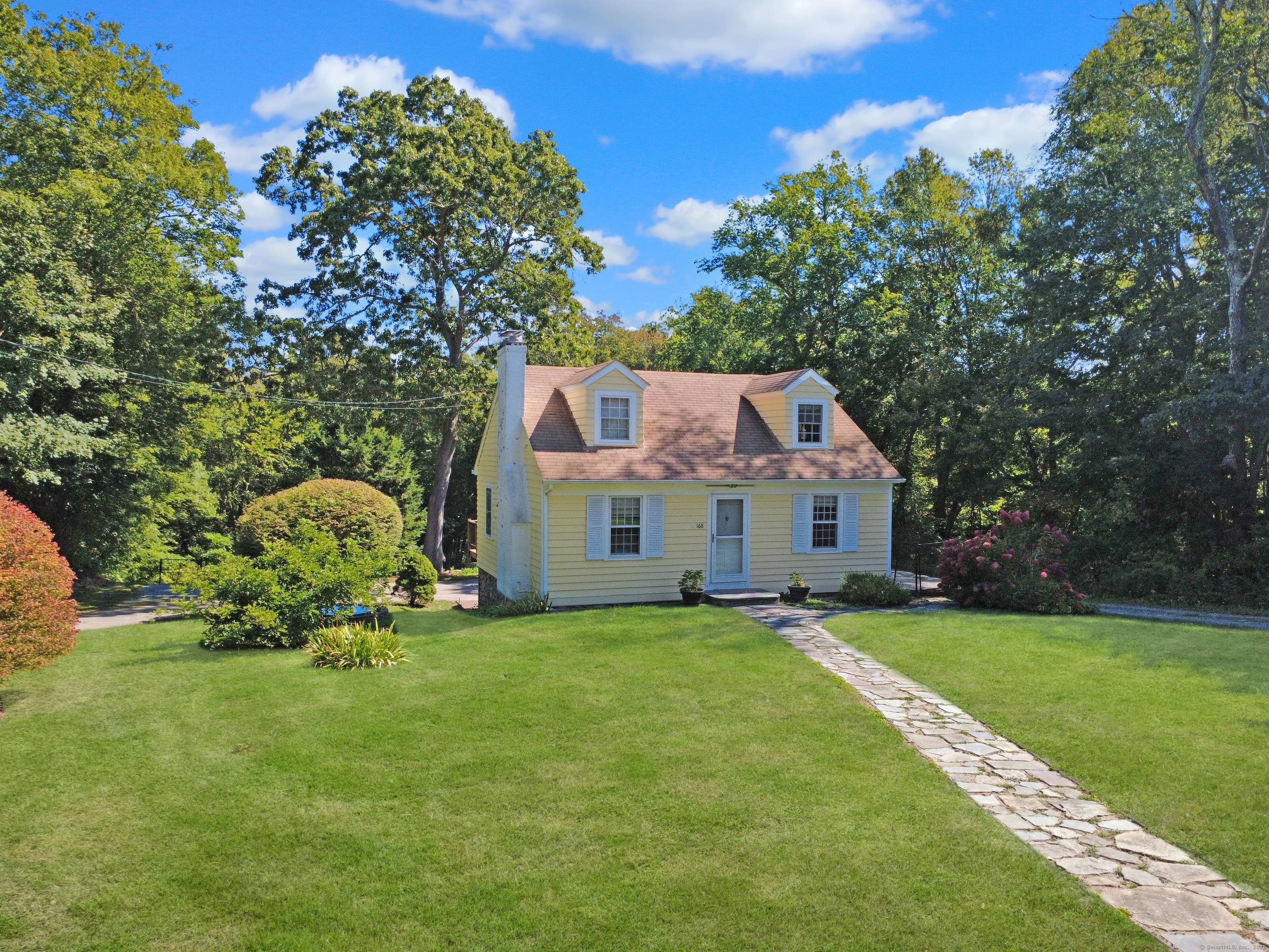 Nestled on a deep lot lined with mature trees for privacy, this inviting 3BR Cape offers classic charm versatile living.