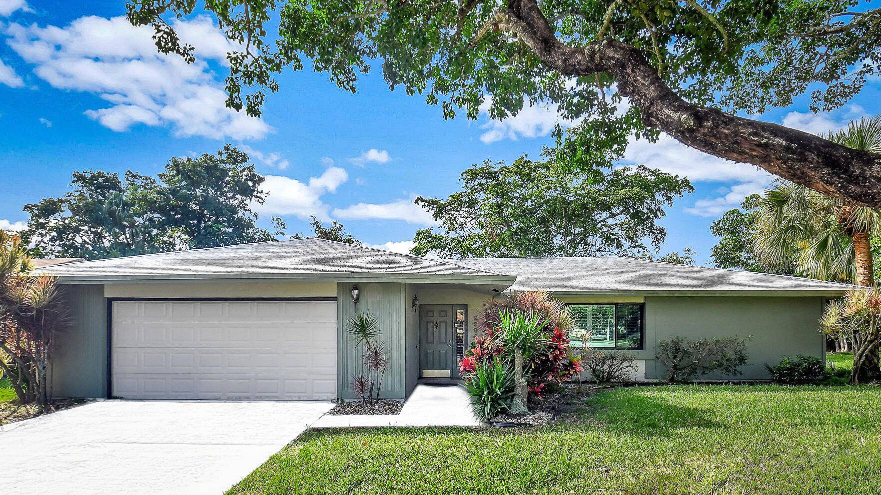 The spacious, open floor plan includes ceramic tile flooring in the main living spaces, laminate wood in bedrooms, custom plantation shutters, and impact glass on every window.