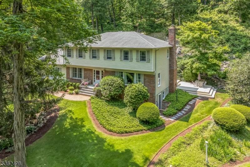 The property features spacious front and side yards, complemented by nearly a quarter acre of tiered rock gardens in the rear your own botanical garden.
