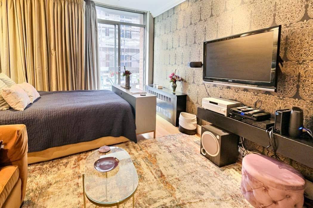 Quintessential Greenwich Village designer furnished studio with a balcony that floats above the treetops, offering views of the Empire Statement Building, Washington Square Park, and the iconic Village skyline.