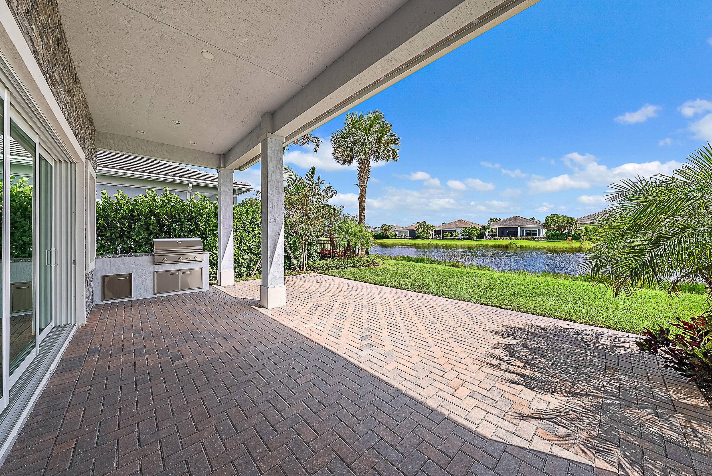 Located in the Tradewinds section of Regency at Avenir, this single story Isabella model with contemporary elevation blends refined finishes with serene lakefront living.