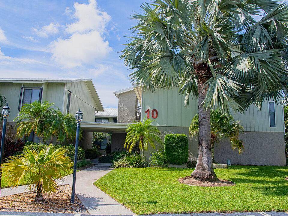 Live minutes from Downtown Stuart in this bright private second floor corner unit with an open, tiled living space featuring IMPACT windows and vaulted ceilings.