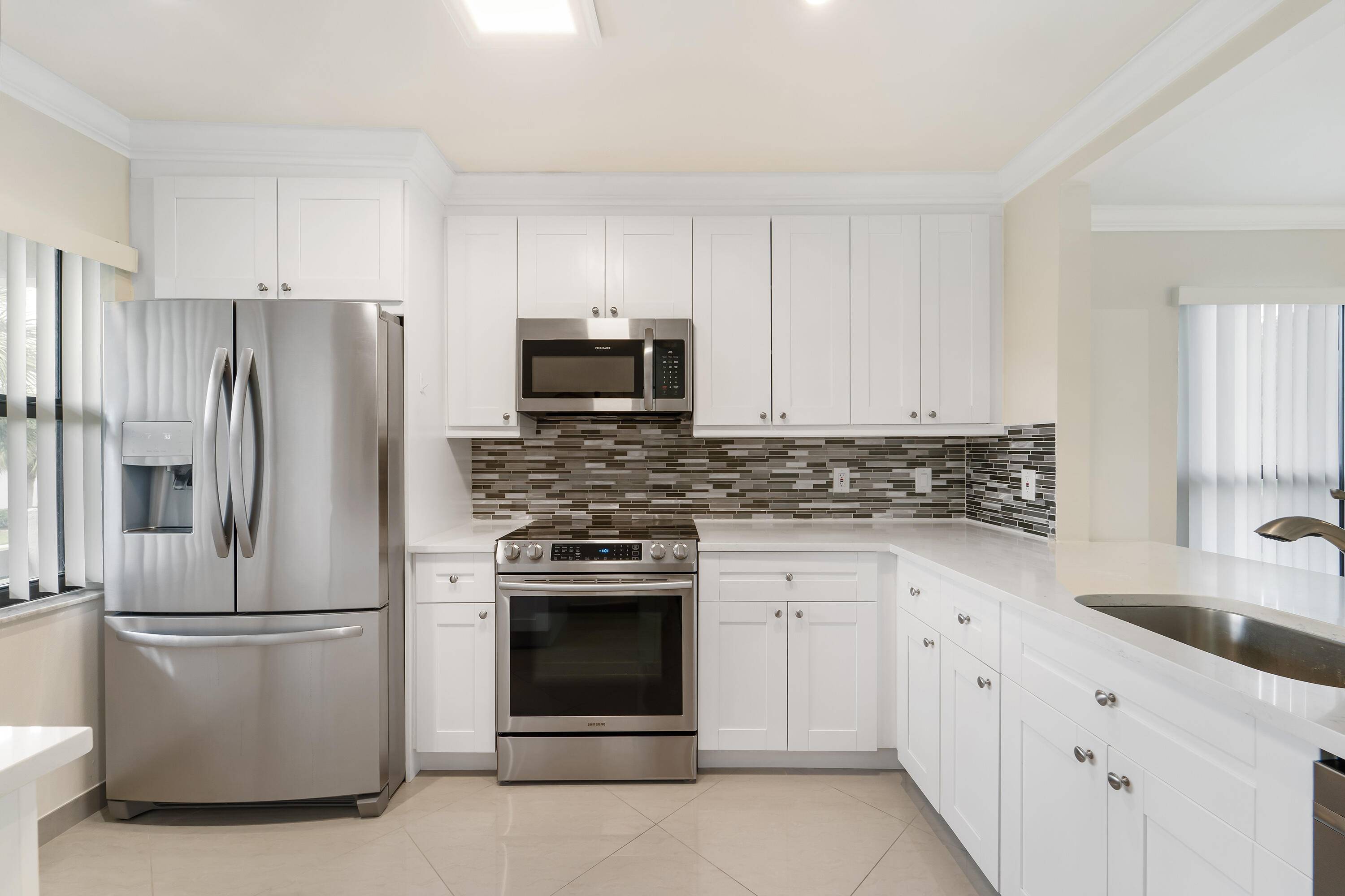 STUNNING UPGRADES ! COMPLETE IMPACT WINDOWS, NEW ROOF 2022, CORNER UNIT, 2022 whirlpool dishwasher, NEWER 2018 stainless Frigidaire refrigerator, oven microwave.