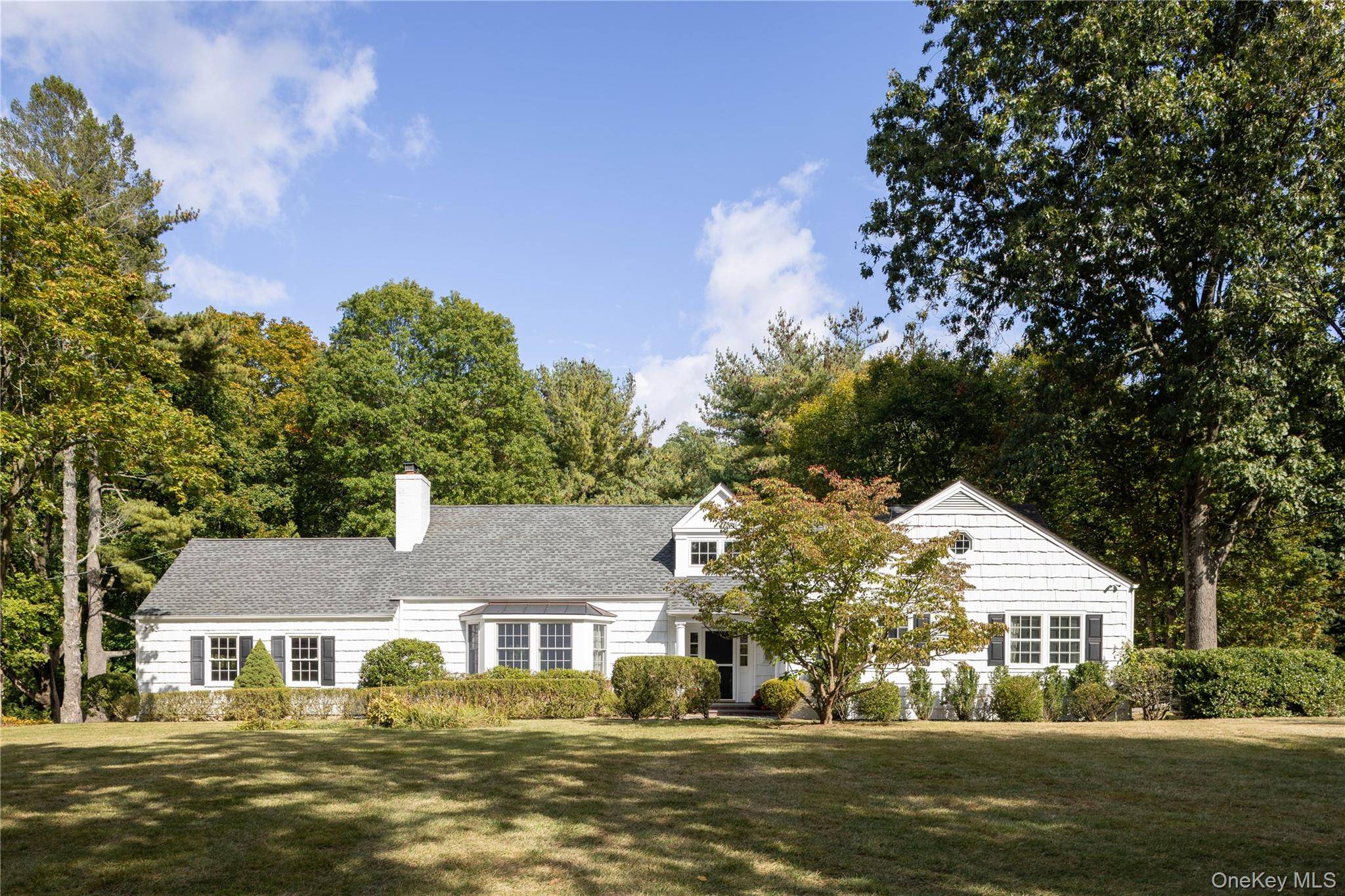 Nestled on one of the most coveted private roads in Locust Valley and adjacent to Coffin Woods Nature Preserve, this charming expanded cape sits gracefully on over 2.