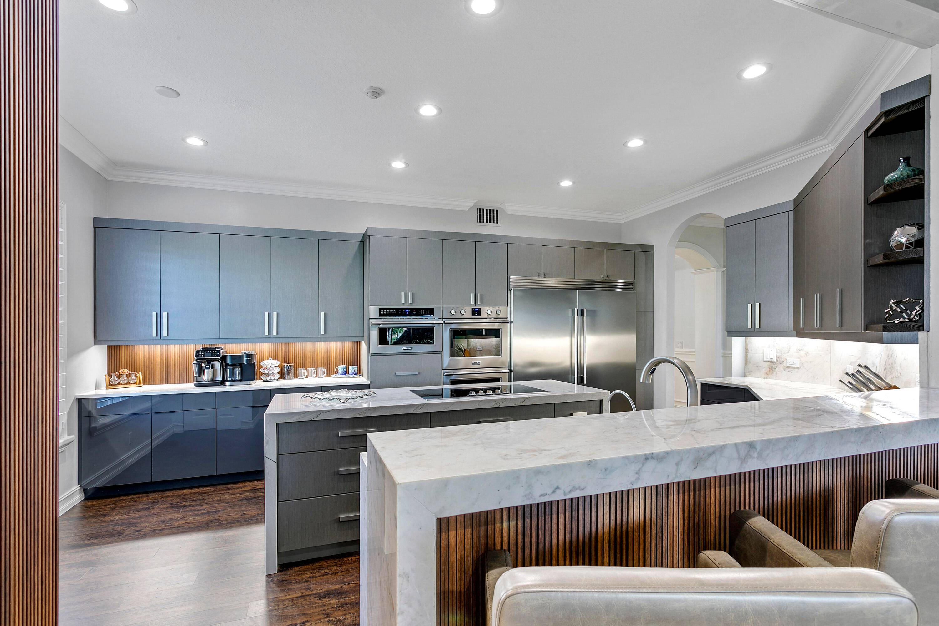 Spectacular golf course view and a fully renovated custom kitchen make this first floor luxury condo with impact windows a special find.