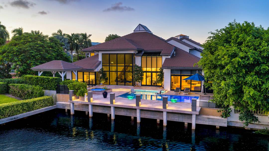 Blending contemporary architecture with lofty urban chic, this dramatic yachting estate offers a voluminous open floor plan with stunning interiors, serene water views, and direct ocean access.