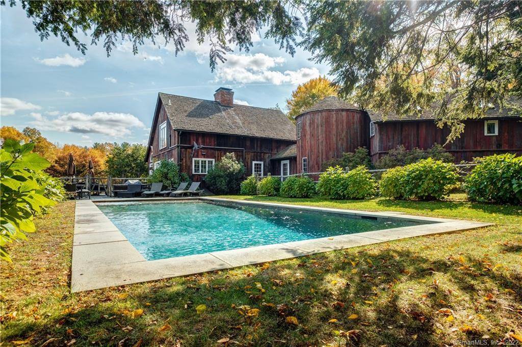 Magical Barn Style Home composed of 3 Barns and a Silo set on a manicured lawn and apple orchard.