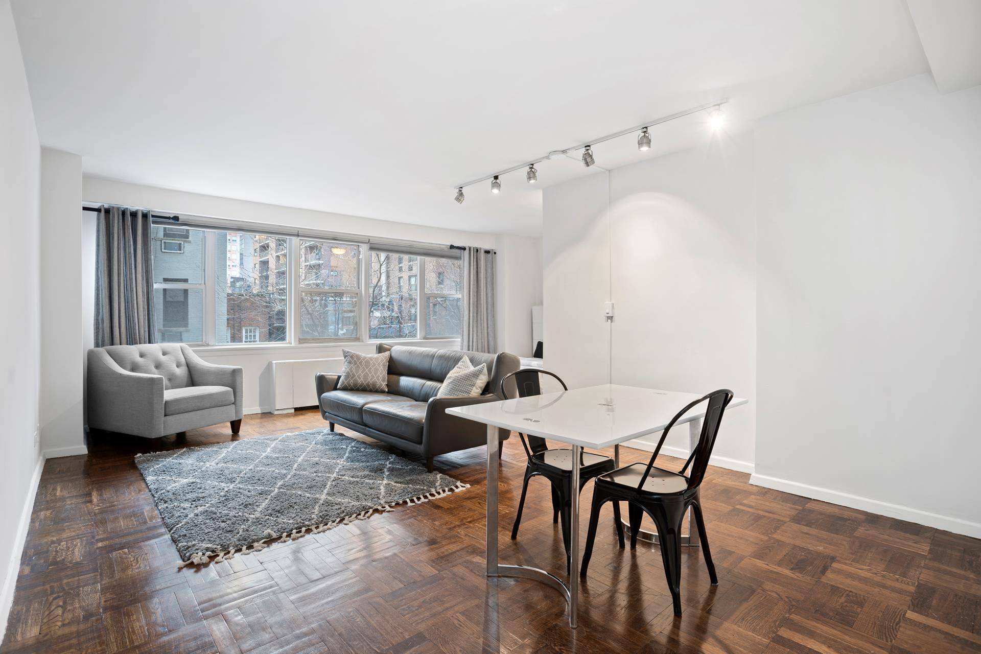 Oversized sunny alcove studio with high ceilings and large living space with a wall of windows facing north.