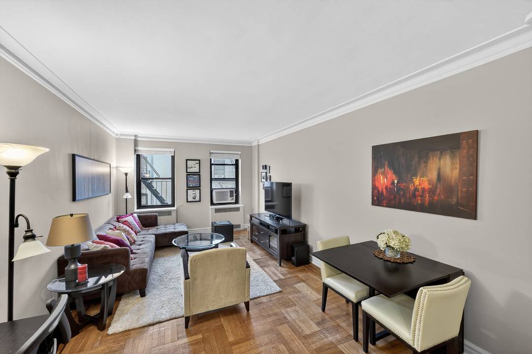 Gracious and spacious pre war corner one bedroom featuring classic Art Deco architectural details, including a step down living room, elegant arched entryways, hardwood floors, and soaring high ceilings.