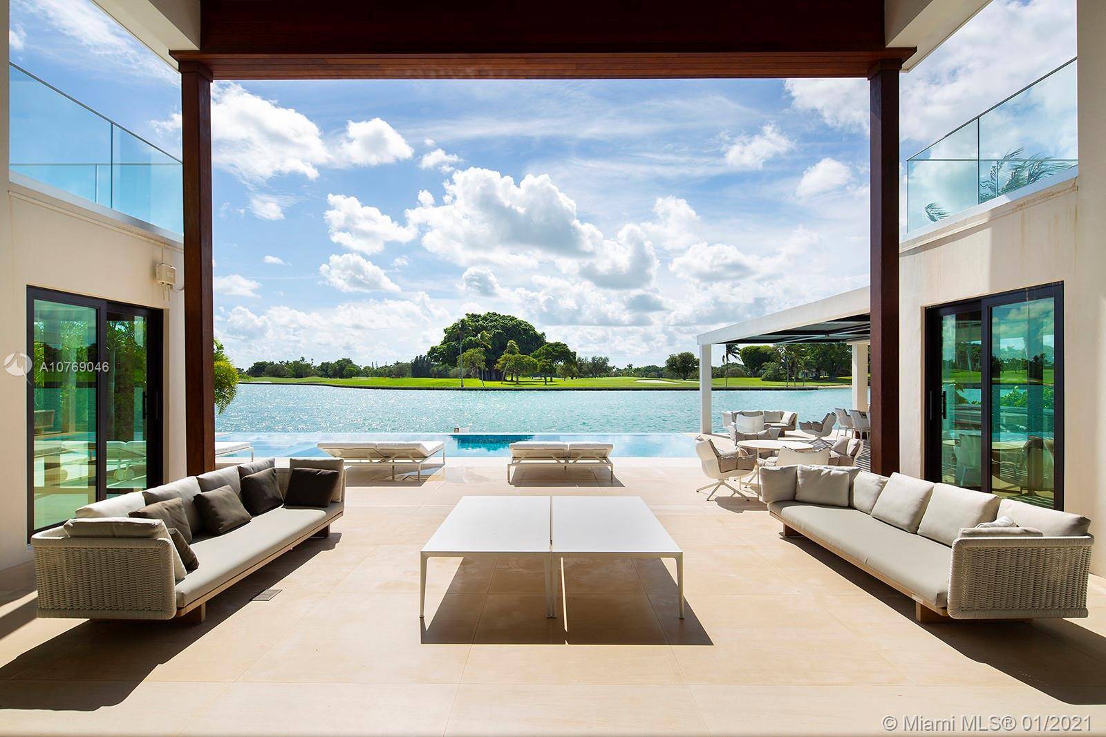 Sweeping southern wide bay water views over Indian Creek Golf Course from this stunning luxurious modern waterfront home in Bay Harbor Islands.