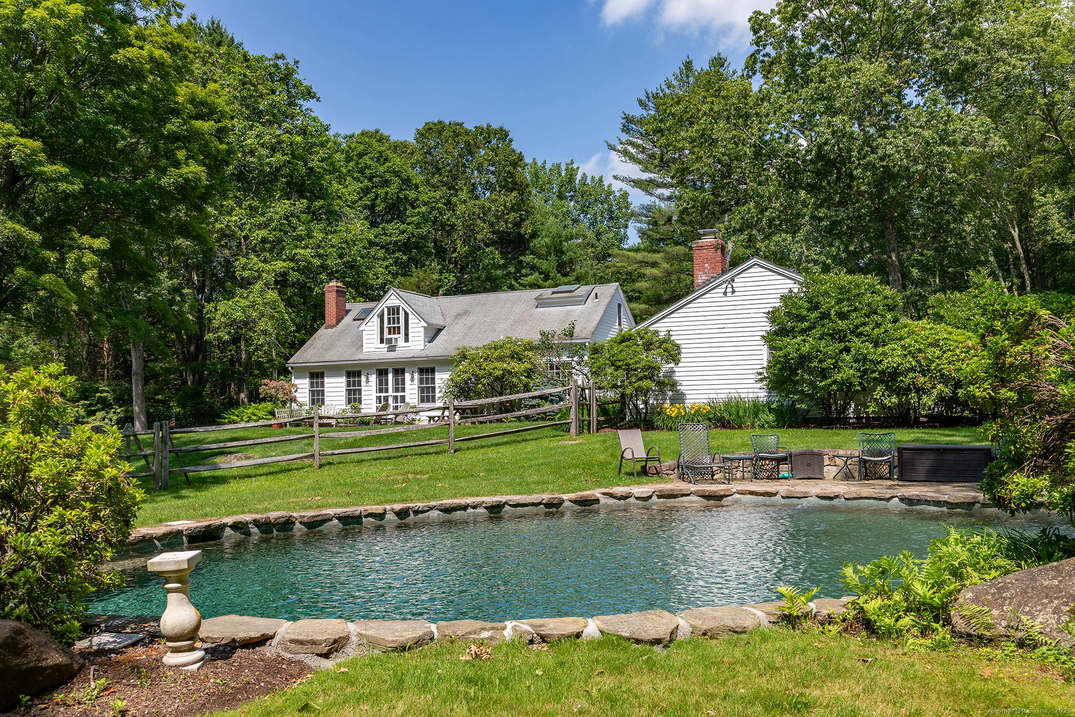 Charming 3 bedroom, 3 bathroom, cottage on a private 13 acres with a heated saltwater gunite pool, guest cottage, stunning grounds, and perennial gardens.