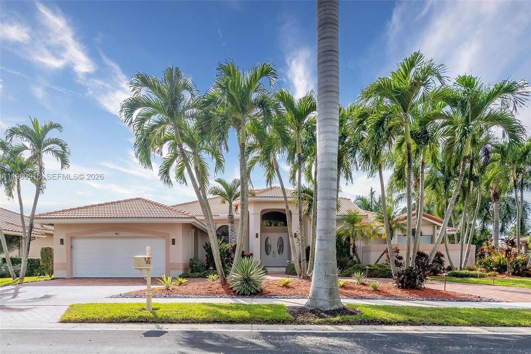 This elegant residence is set on a private oversized corner lot within the prestigious guard gated community of Palm Island in Weston.