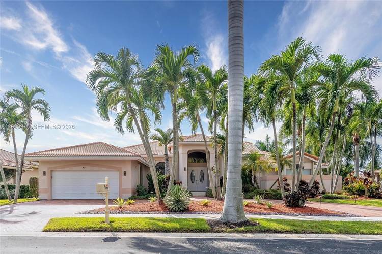 This elegant residence is set on a private oversized corner lot within the prestigious guard gated community of Palm Island in Weston.