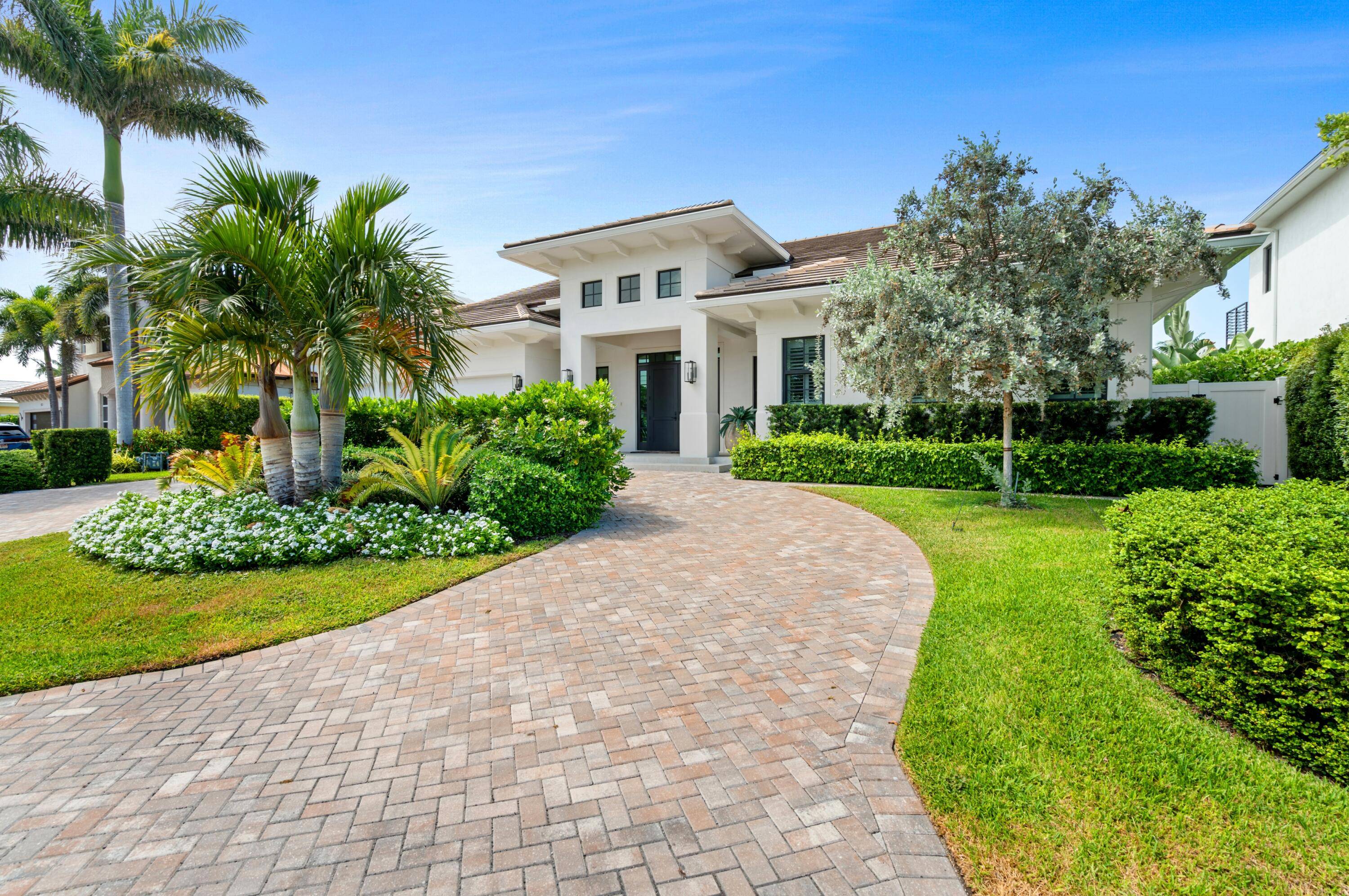 Chic 2022 built estate in desirable Tropic Isle, Delray Beach, offers 90 feet on a canal with a dock off the Intracoastal.