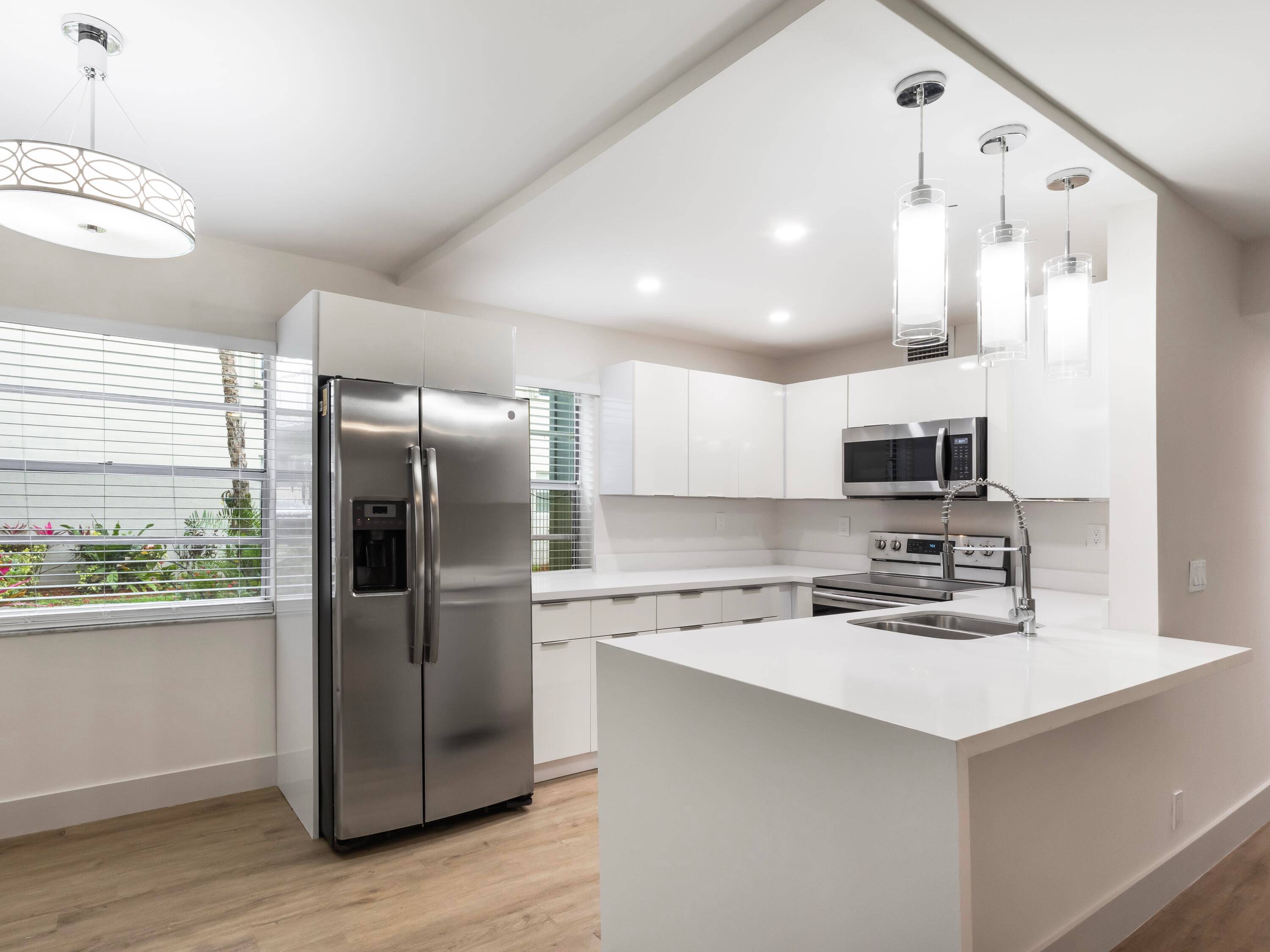 This beautifully updated condo features a stunning kitchen with white cabinetry, quartz countertops, and stainless steel appliances.