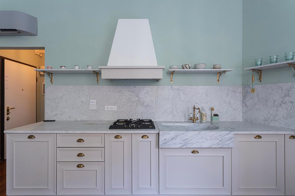 Kitchen with marble countertop, marble shelving, and elegant full-wood cabinetry