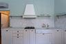 Kitchen with marble countertop, marble shelving, and elegant full-wood cabinetry