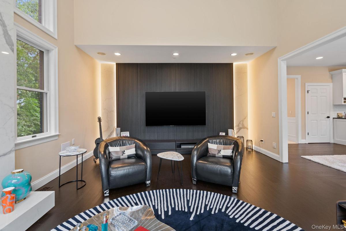 Living room with recessed lighting, dark wood-type flooring, and healthy amount of natural light