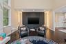 Living room with recessed lighting, dark wood-type flooring, and healthy amount of natural light