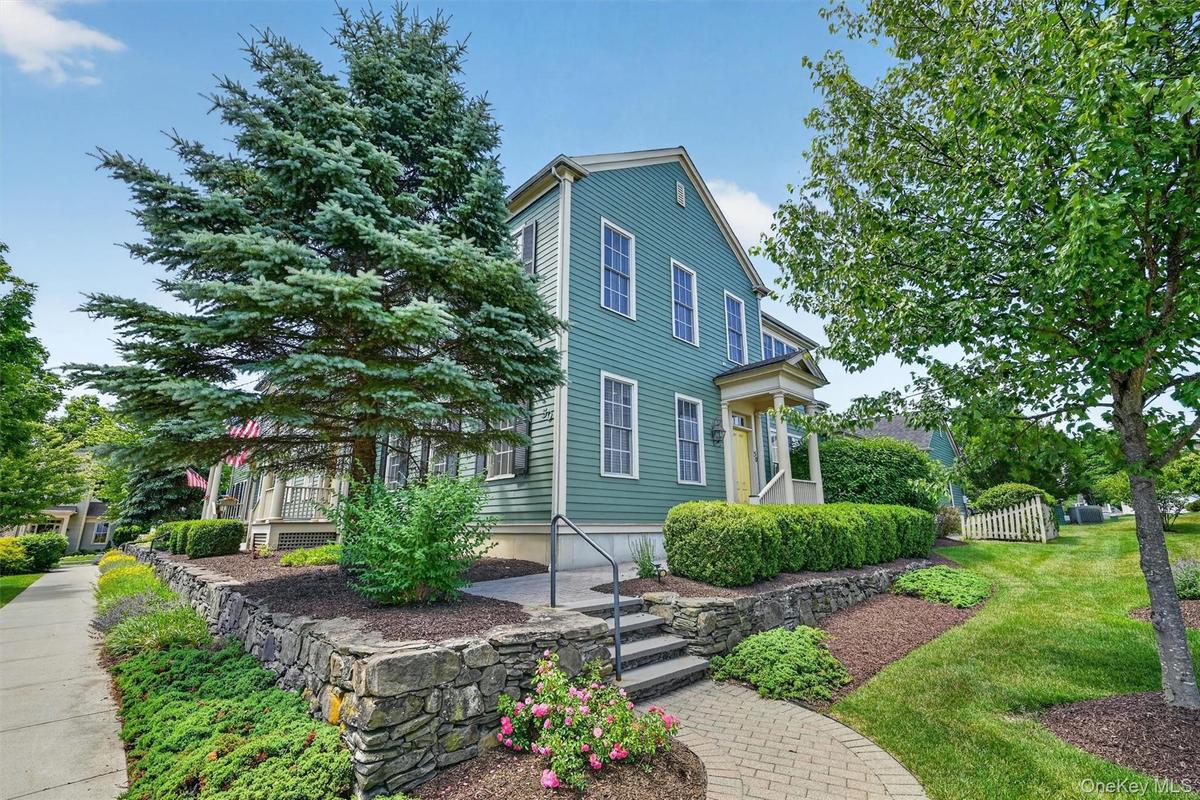 A closer look captures the home’s classic curb appeal, mature trees, stone garden walls, and peaceful surroundings.