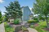 A closer look captures the home’s classic curb appeal, mature trees, stone garden walls, and peaceful surroundings.
