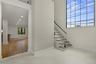 Contemporary staircase featuring wood-finish treads and a glass railing with a black handrail